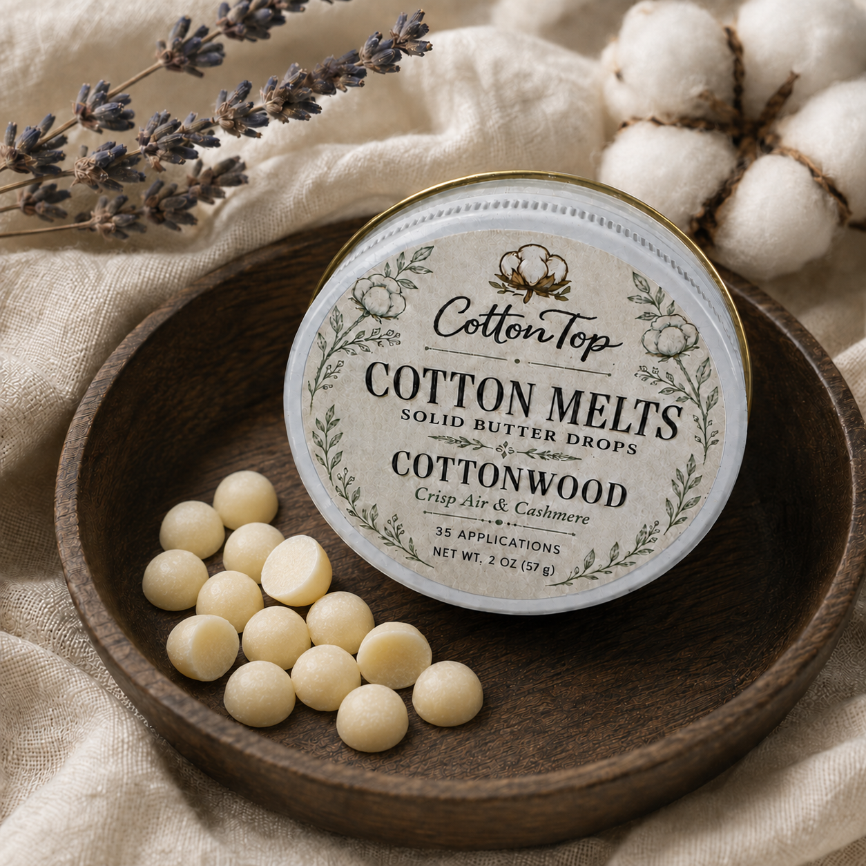 CottonTop Cotton Melts—small individual solid butter drops—beside the Cottonwood tin on a walnut tray